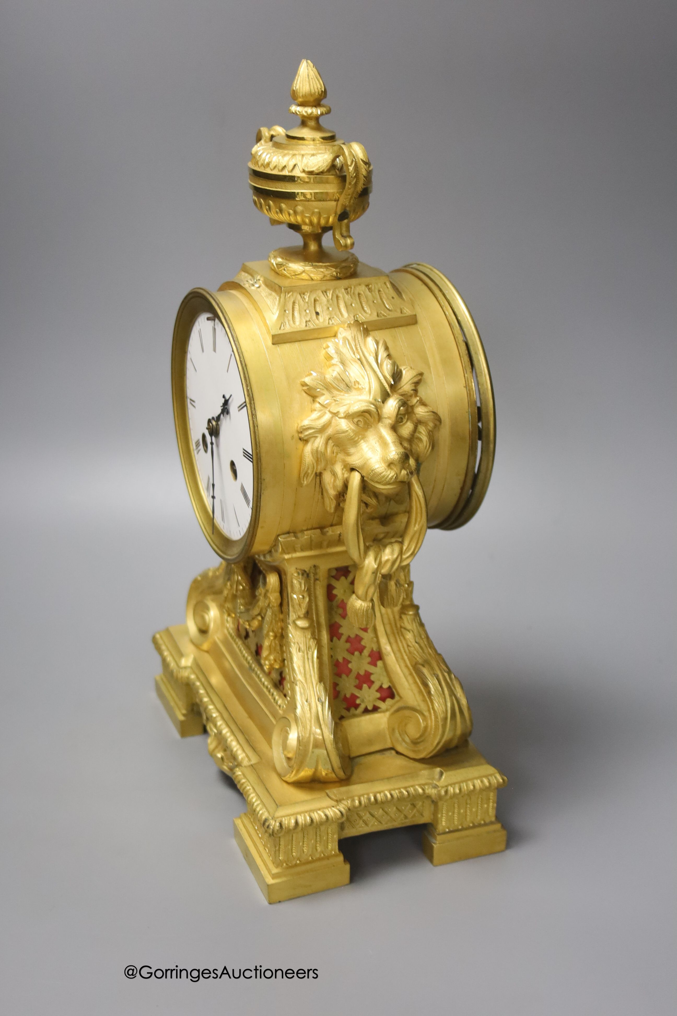 A 19th century French ormolu clock, with lion mask ring handles, 34cm